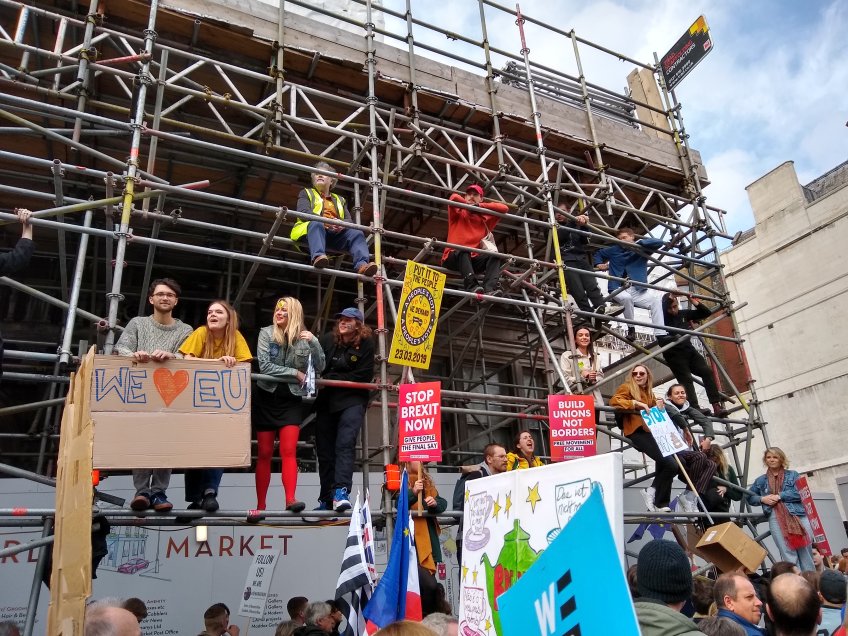 A photo I took on the People's Vote March in October 2018 of young people climbing up on the scaffolding to wave their signs to the 700,000 attendees. By the looks of them, they were probably too young to vote in 2016